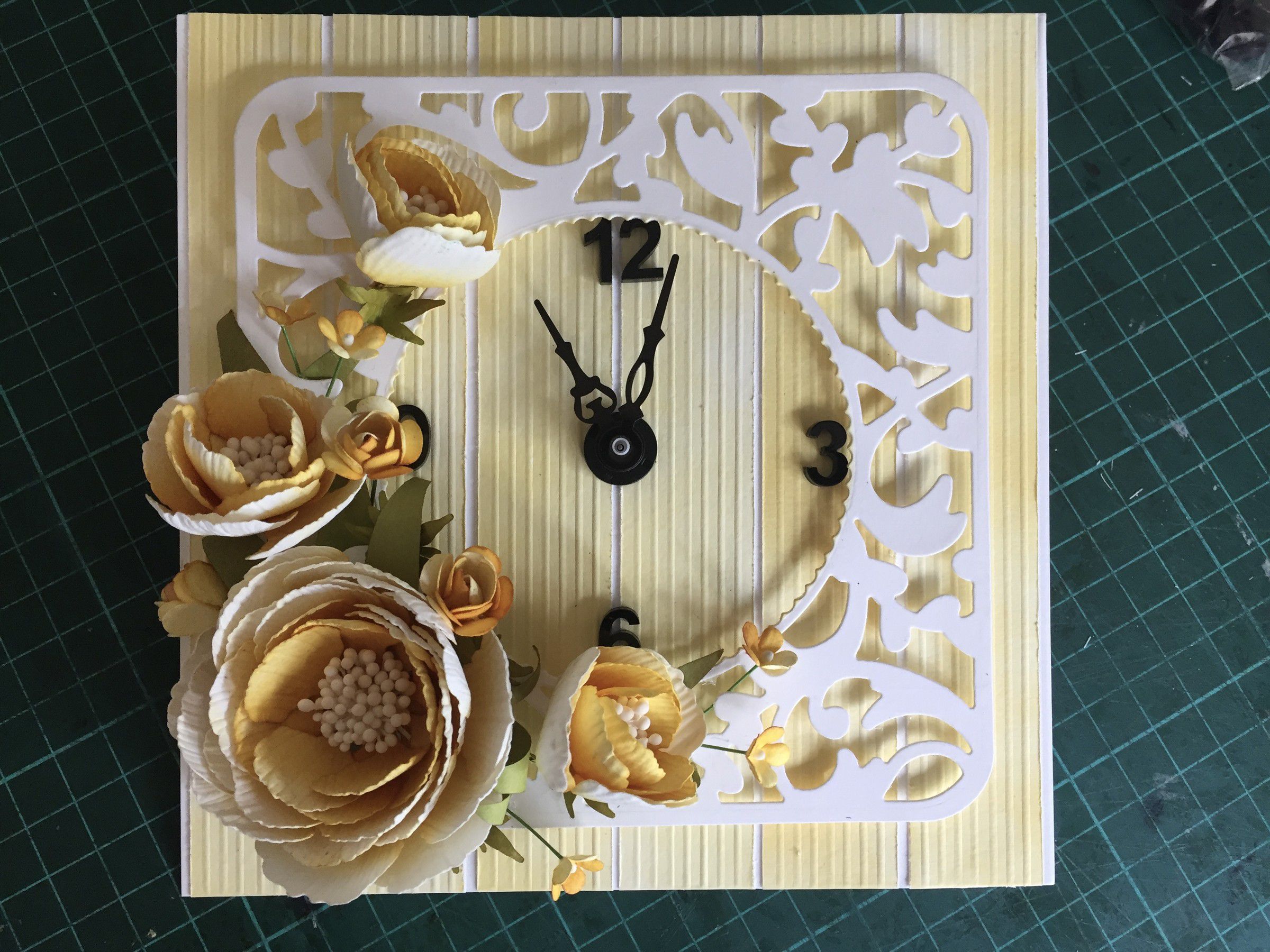 Square paper clock with a white filigree frame, decorated with pale gold paper roses