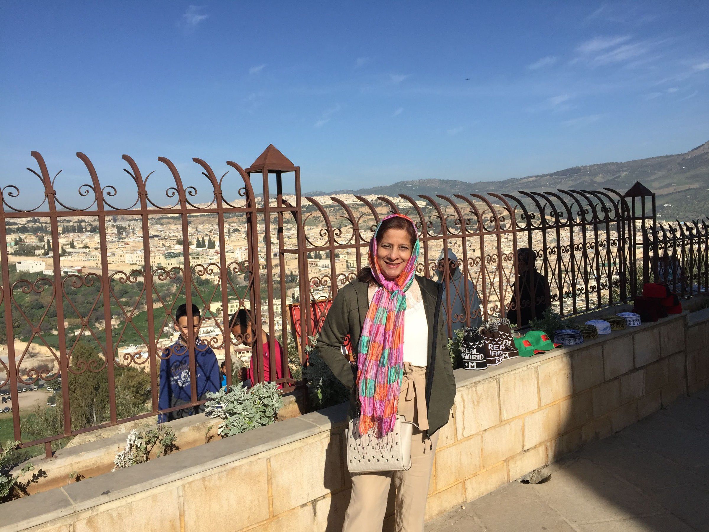 Mugdha in a bright headscarf on a terrace overlooking a sprawling city